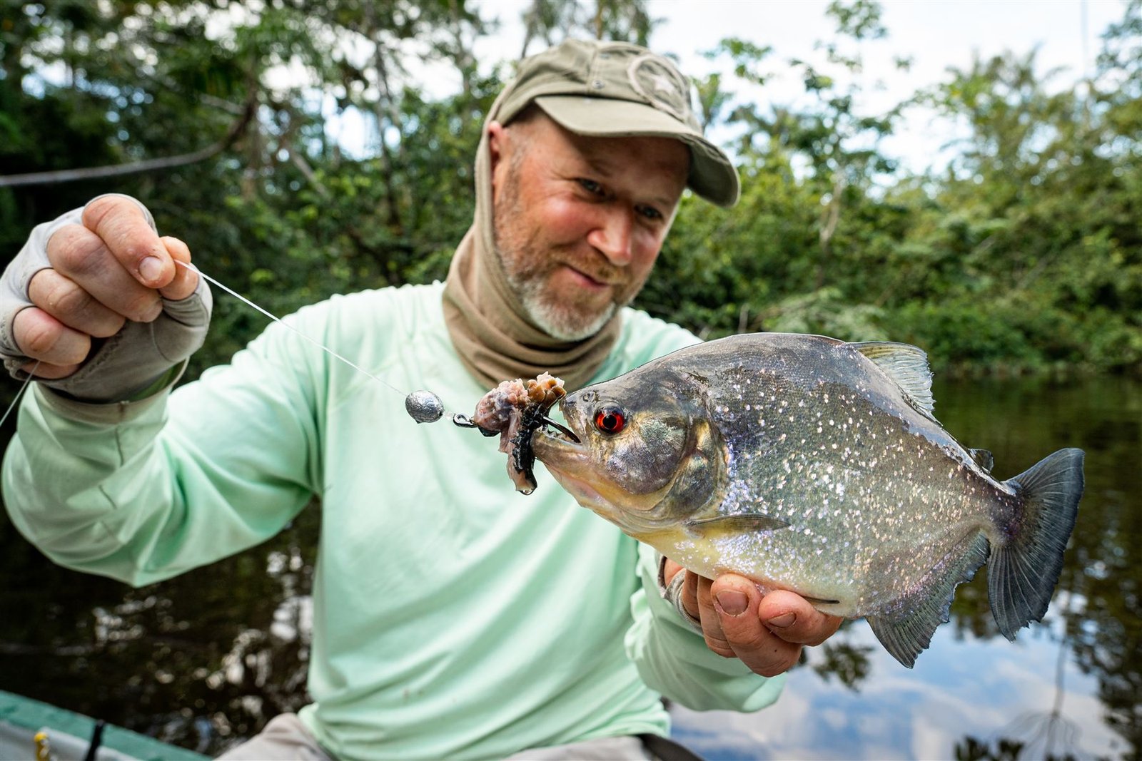 A guest holding a piranha caught on a hand line