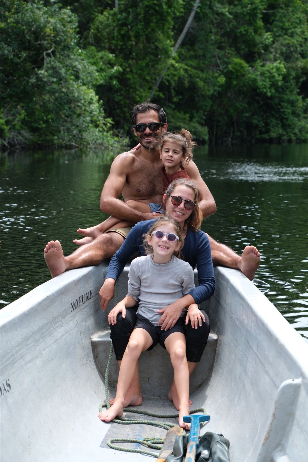 A family in the bow of the canoe running the forest river